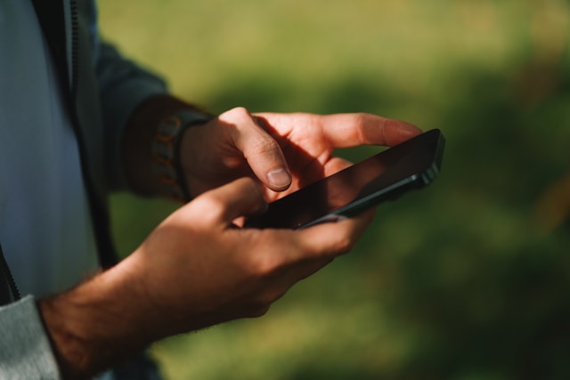 Person checking phone in the sun